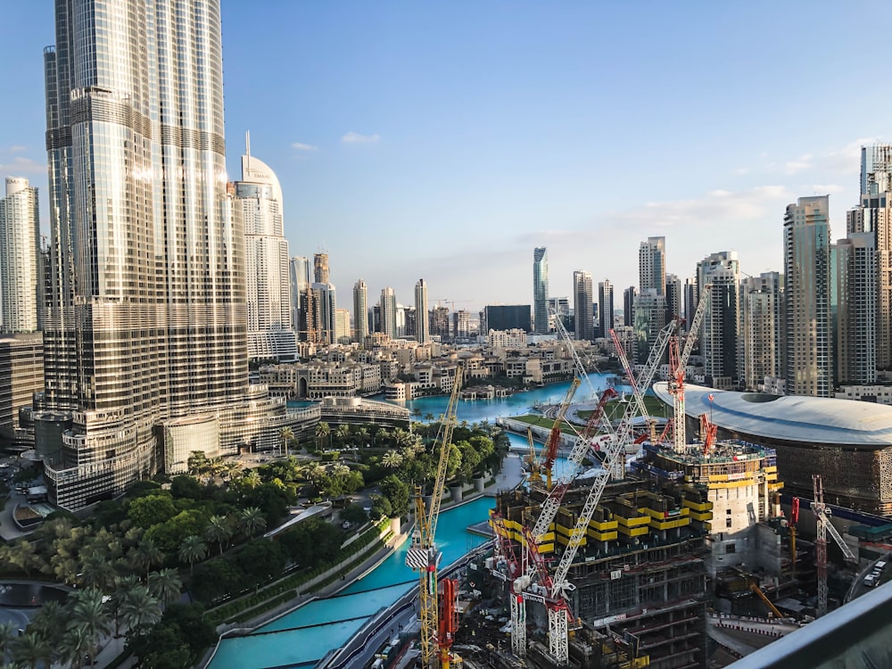 several boom cranes at the building construction site along the city river