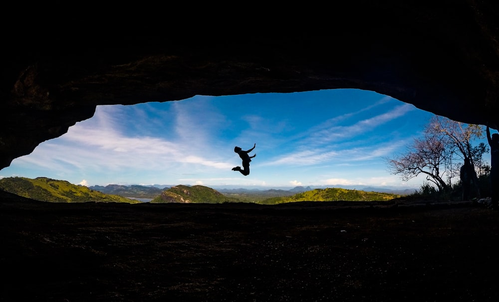 time lapse jumpshot photography of person from a cave