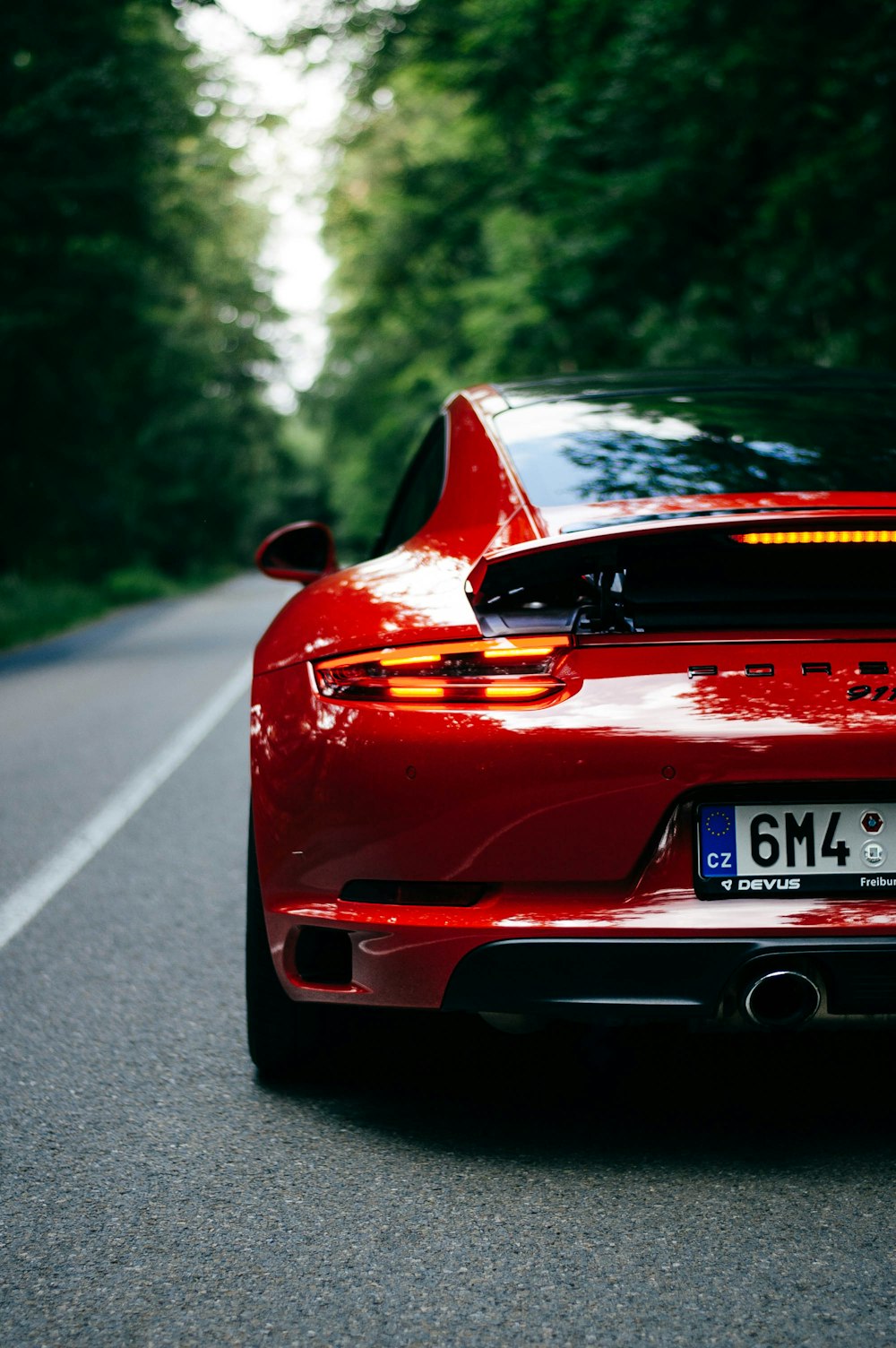 back view of red sport car on the road