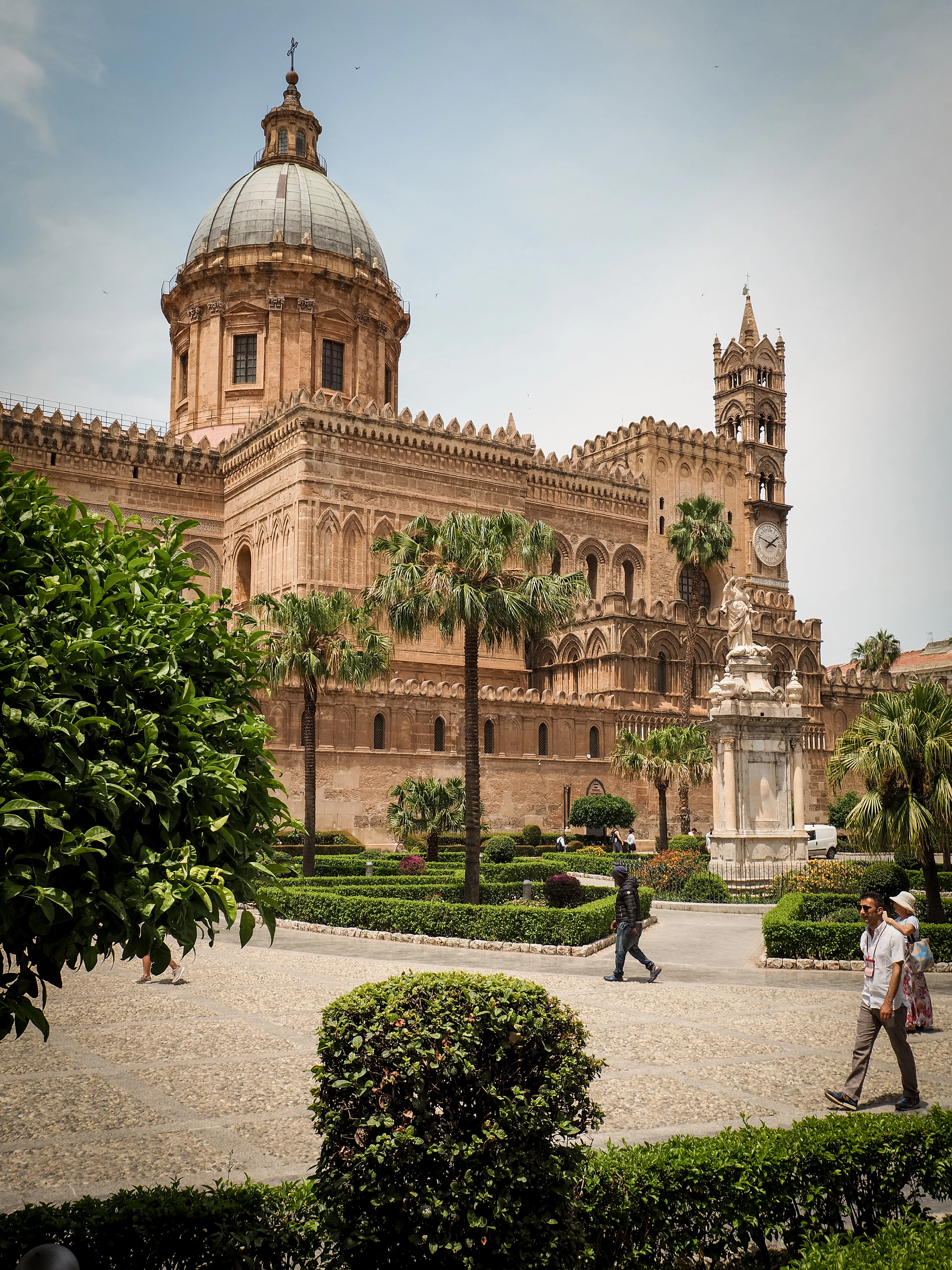 Palermo Cathedral with its dome, arabesque arcades and palm-filled gardens on a summer day in Sicily