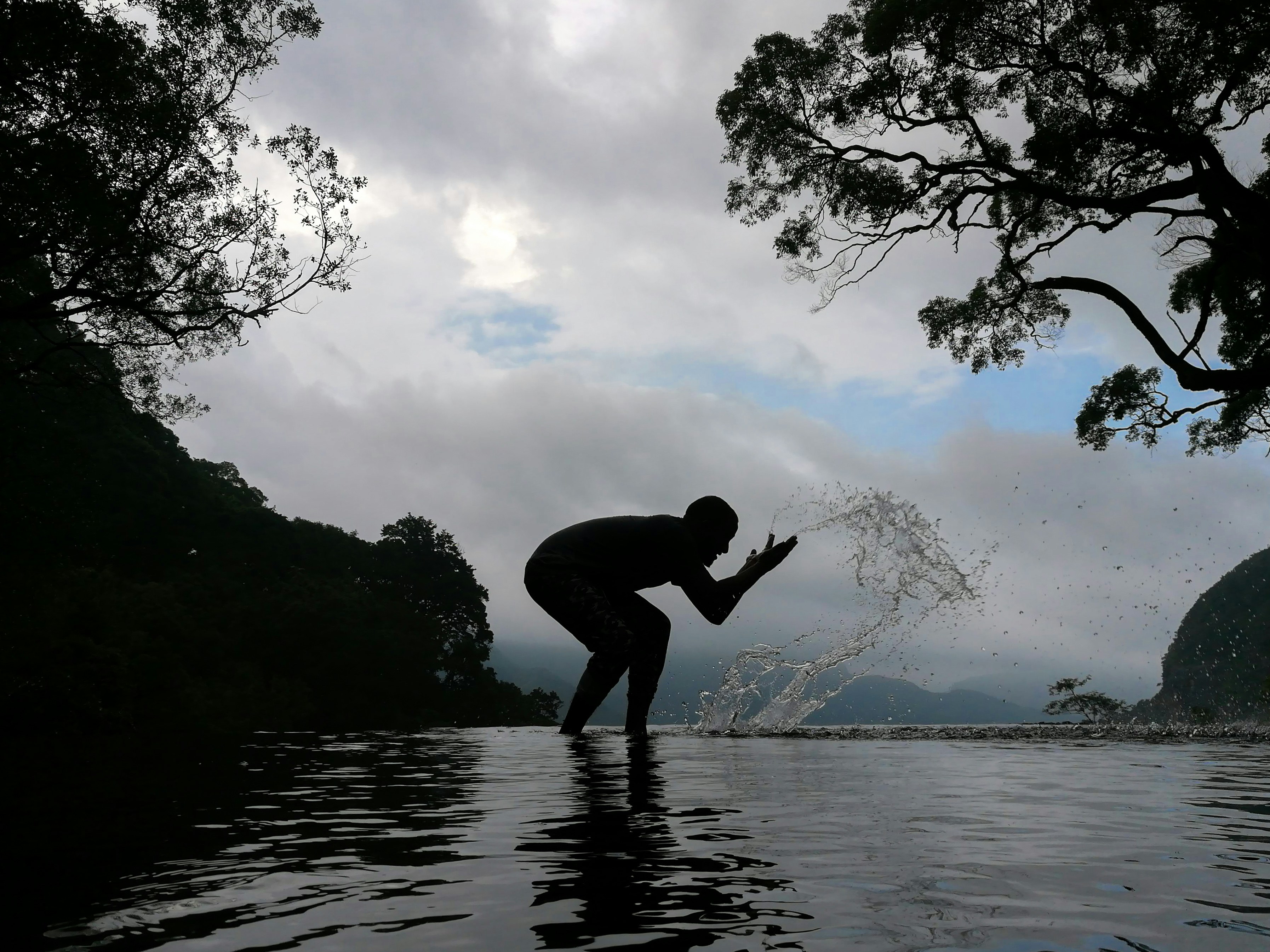silhouette of person splashing water