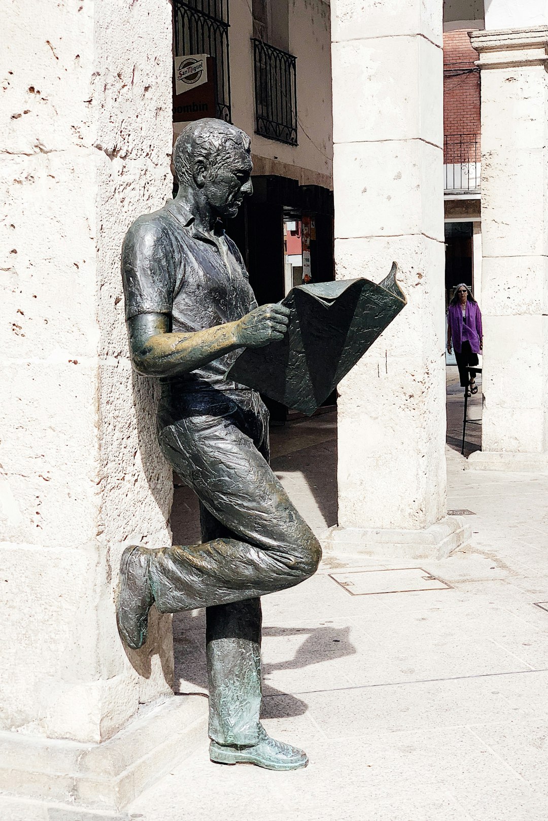 man reading newspaper statue