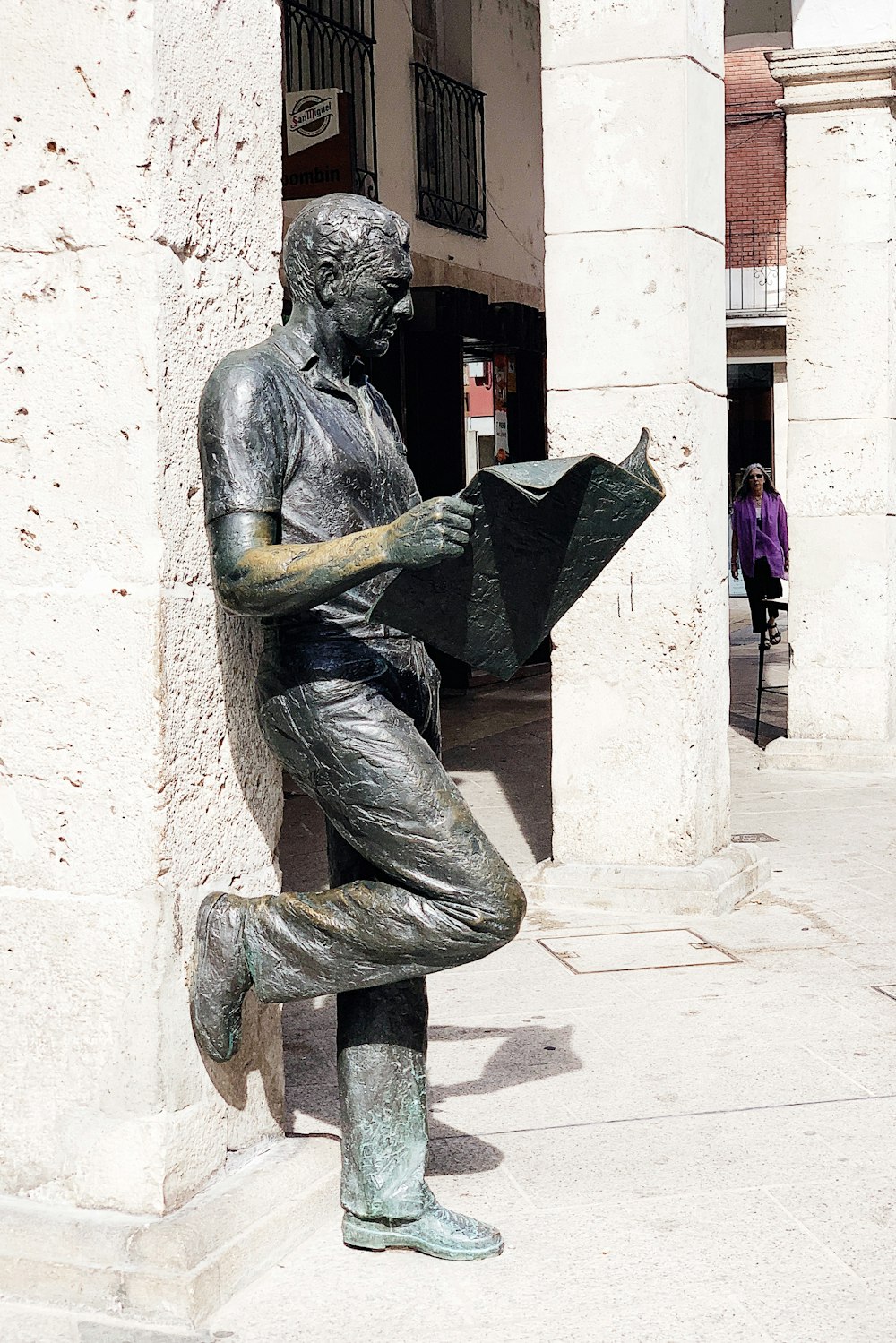 man reading newspaper statue