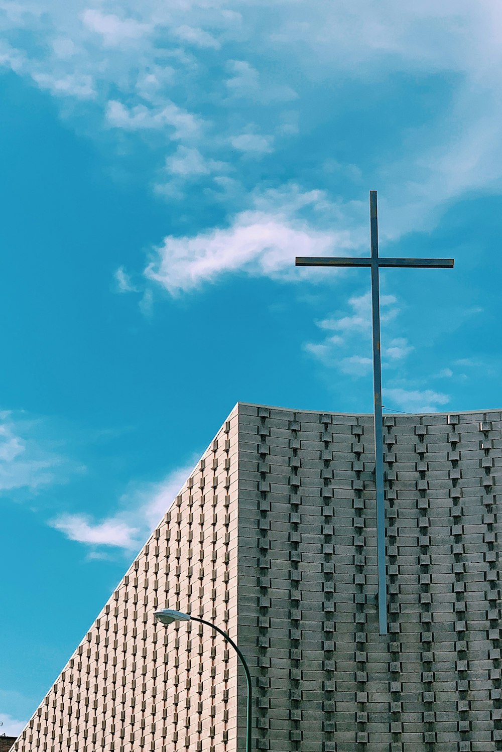 gray steel cross on brown building photo