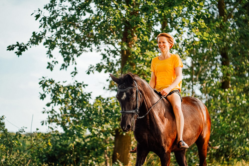 woman riding horse during daytime