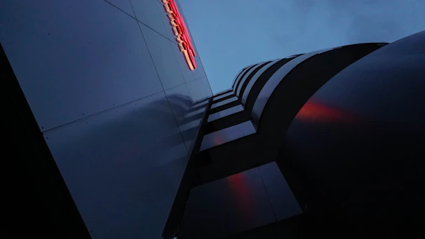 Wide angle of a building facade at sunset, showing AI inspection data points glowing softly.