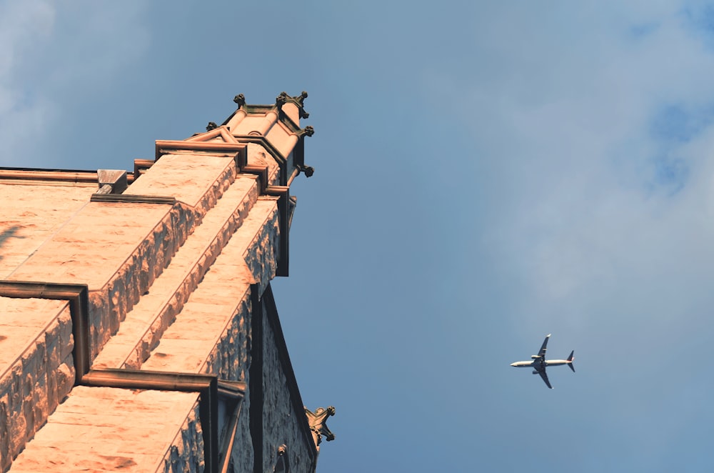 Cattedrale dipinta beige e scenario a mezz'aria dell'aeroplano bianco