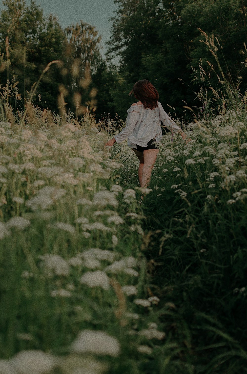 girl running in white flower field during daytime