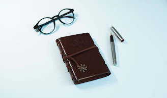 A minimalist black journal with a sleek pen placed diagonally across it.