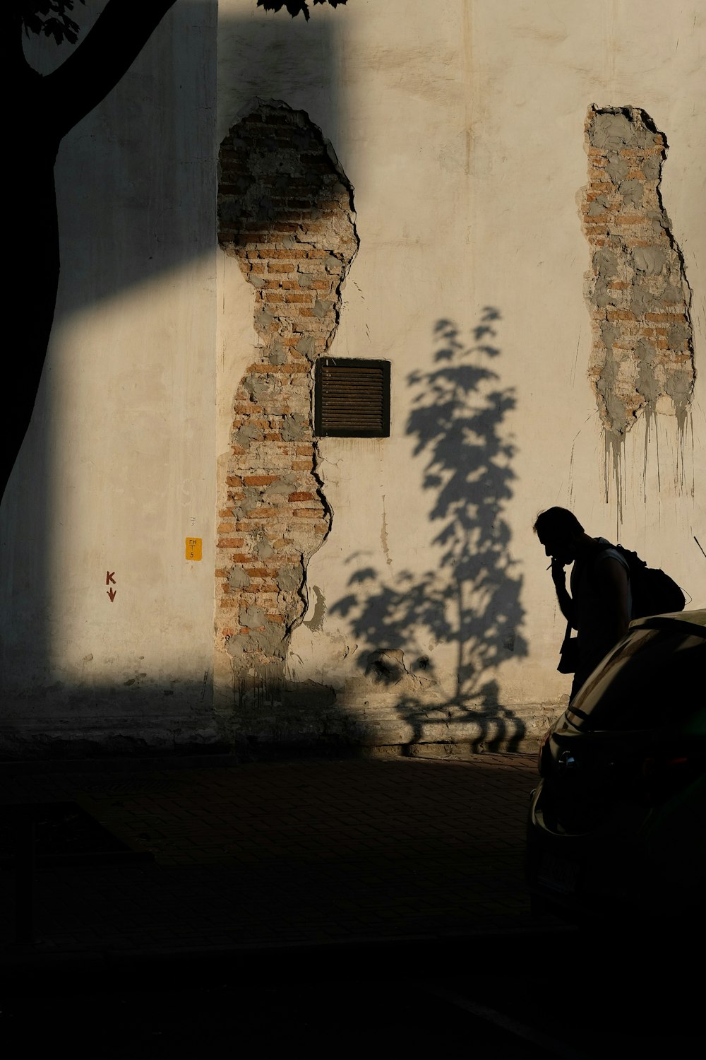 man standing near beige wall