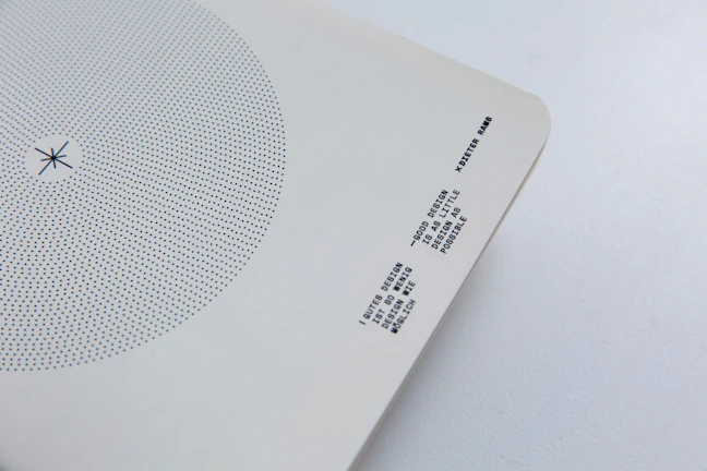Close-up of the minimalist 1bu logo embossed on smooth white paper with subtle neon cyan pulse lighting.