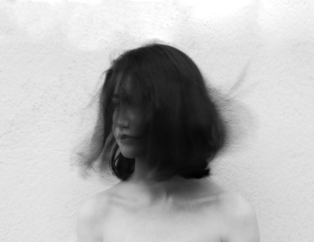 grayscale photography of woman flipping her hair,