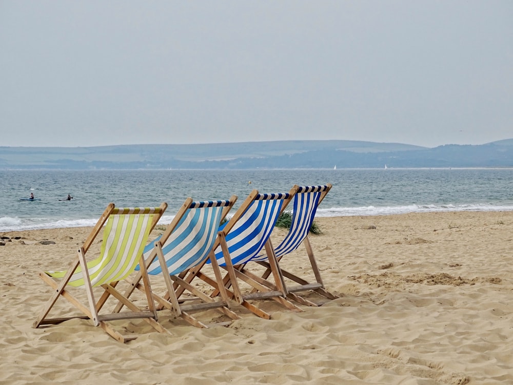 vier Stühle vor dem Strand aufgereiht