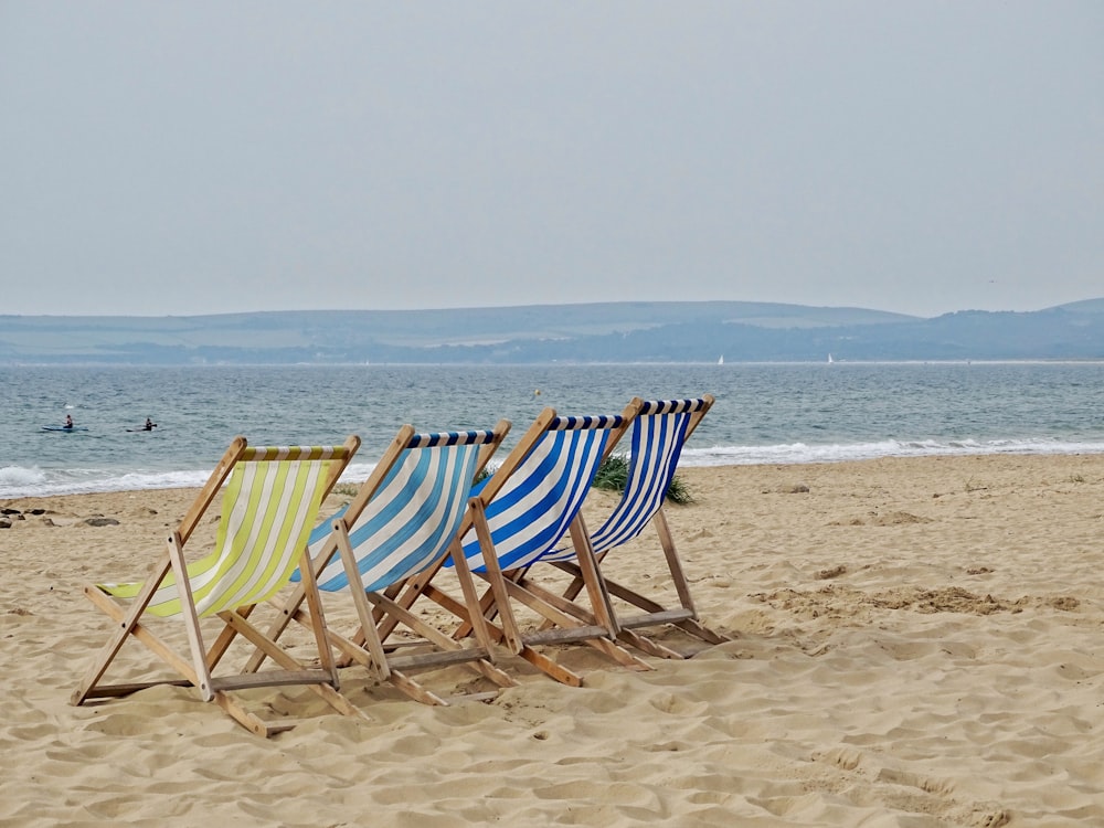 lined four chairs in front of beach