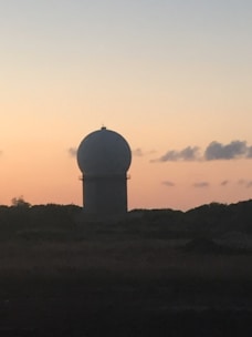Close-up of a radar antenna array scanning the horizon at dusk.
