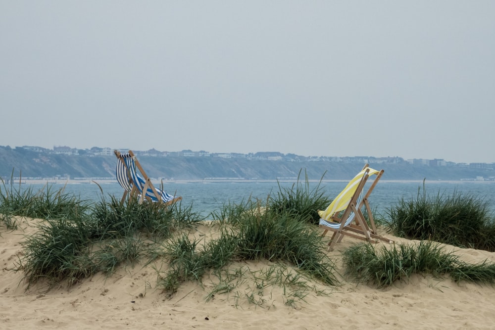 two yellow and brown loungers on shore