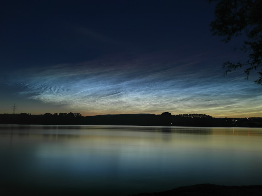 a body of water with a sky in the background