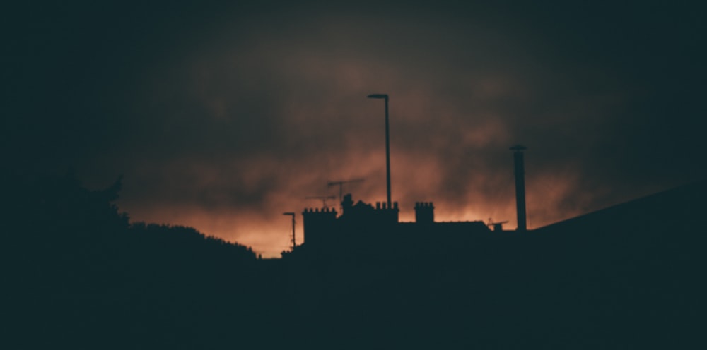 a dark picture of a building with smoke coming out of it