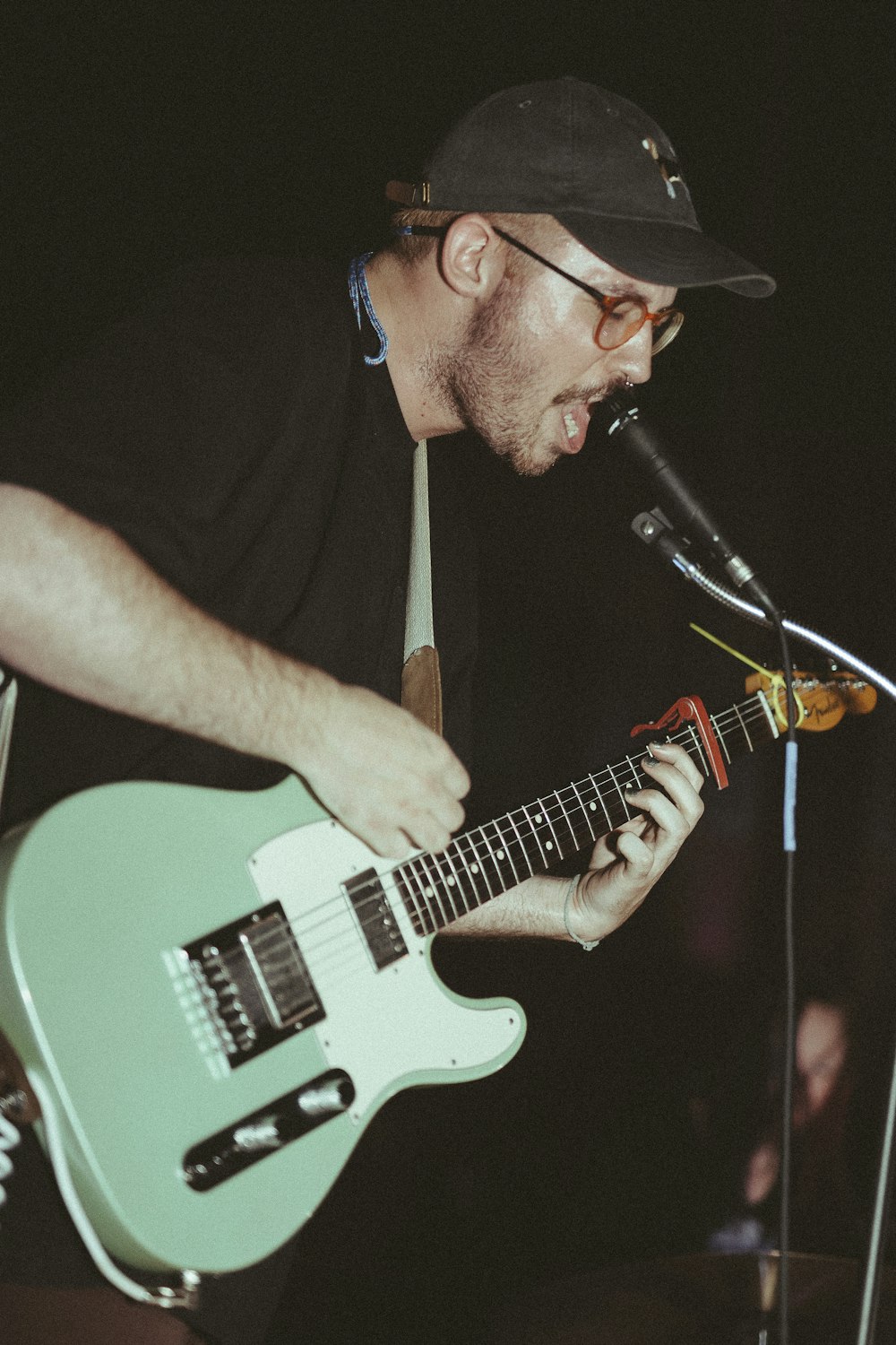 man in black cap playing guitar