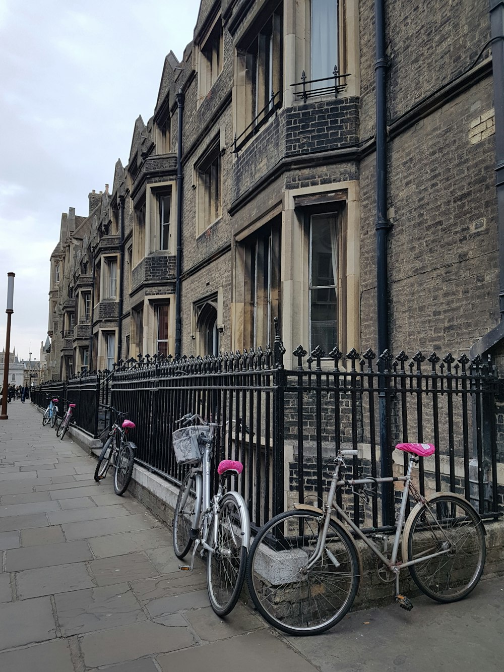 bicycles parked on metal fence of a buildings