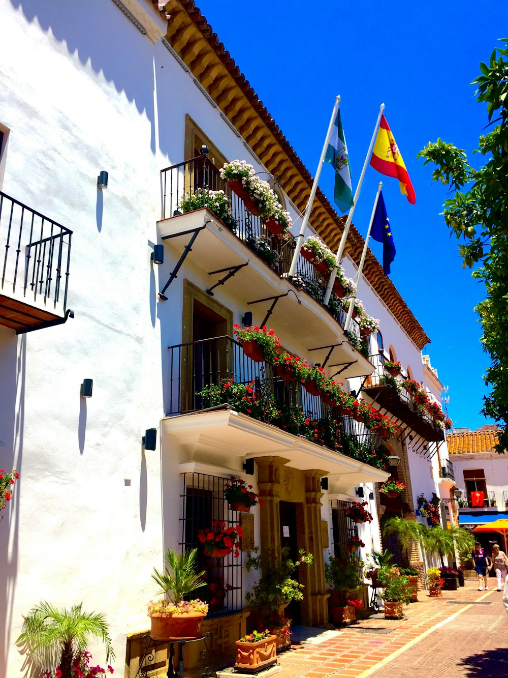 building with flags and flowers on it's balcony during day