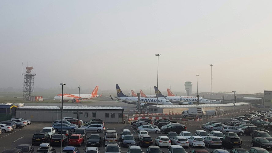 Rows of parked cars in an airport long-term parking lot