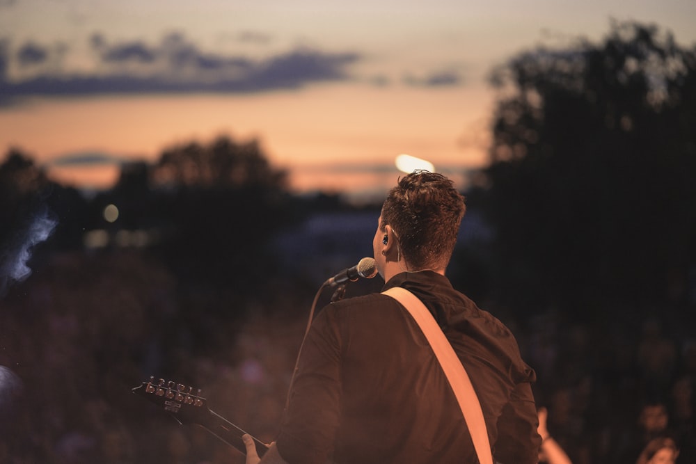 man signing while playing guitar