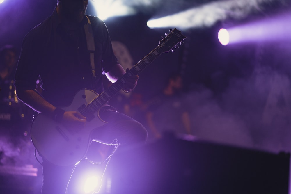 man wearing black dress shirt performing stage