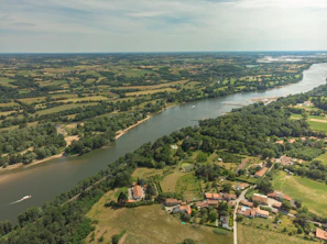 Expansive aerial view of pristine land parcels framed by winding river and dense foliage.