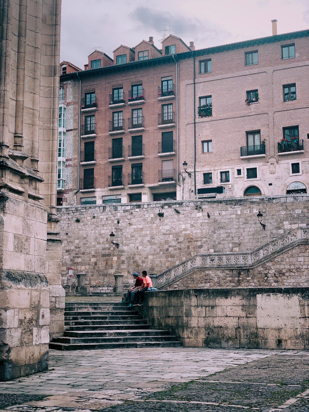 two man sitting near stairs during daytime