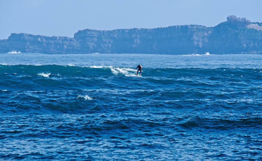 man surfing at the ocean during day