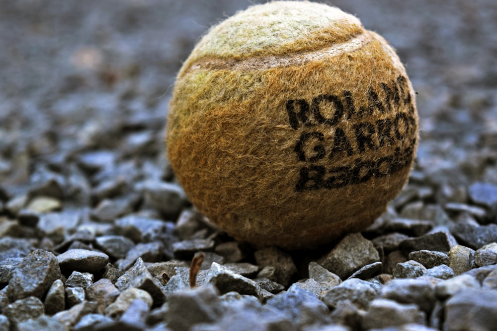 selective focus photography of tennis ball on rocks