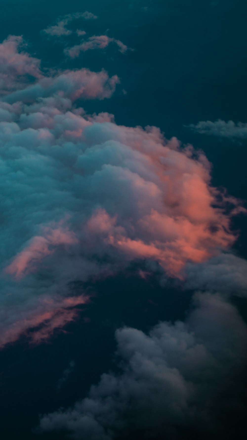 a plane flying through a cloudy blue sky