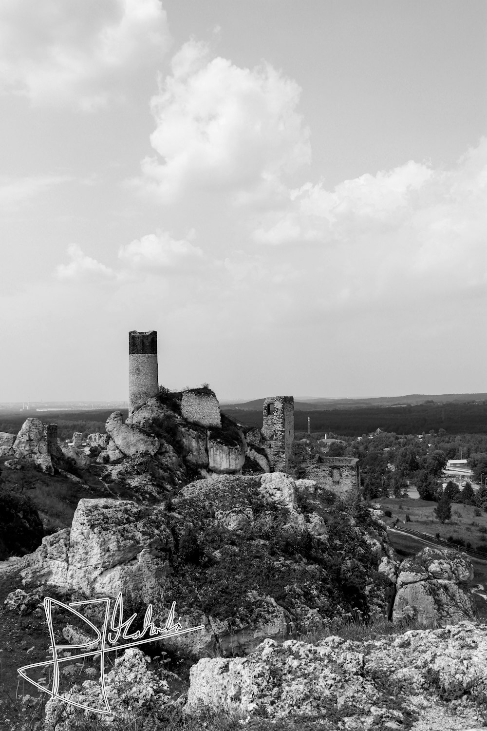 grayscale photo of rocky hill viewing houses