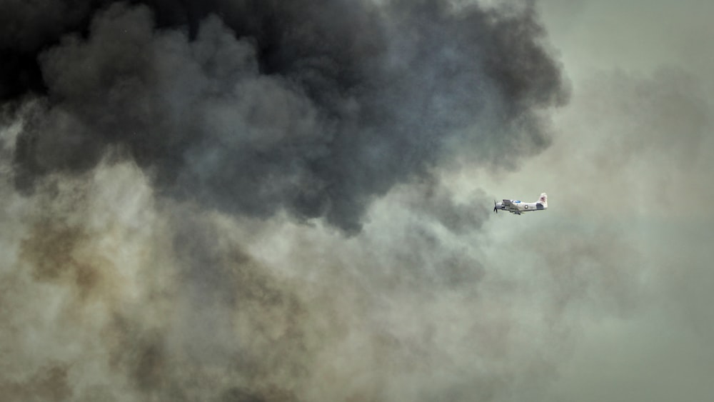 flying plane under cloudy sky during daytime