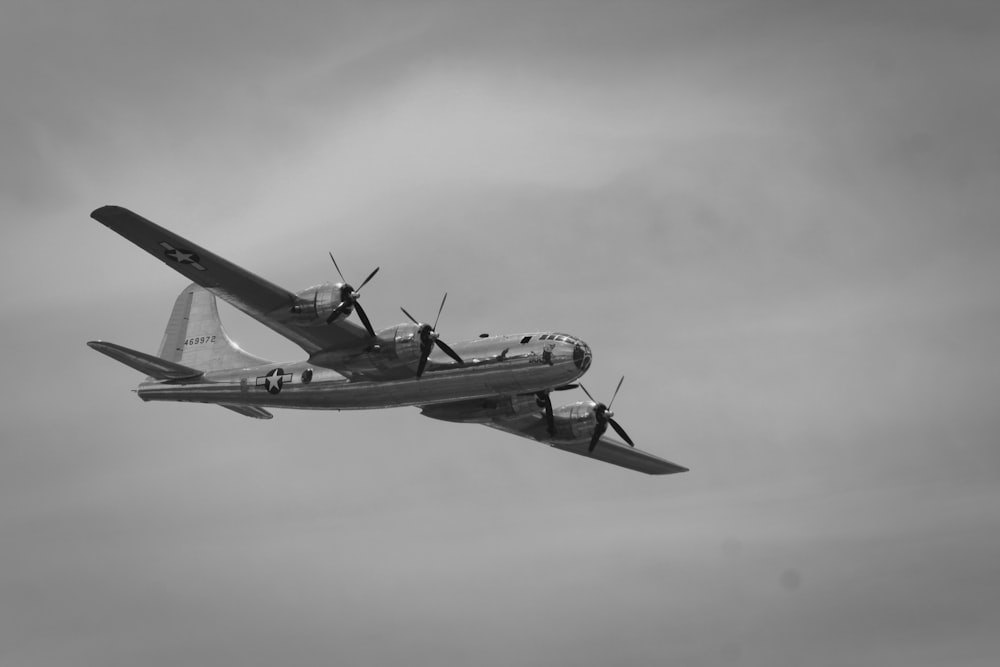 Graustufenfotografie eines fliegenden Flugzeugs