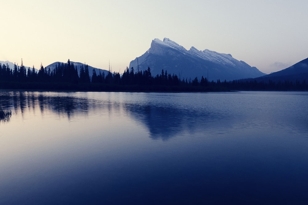 body of water near mountain during daytime