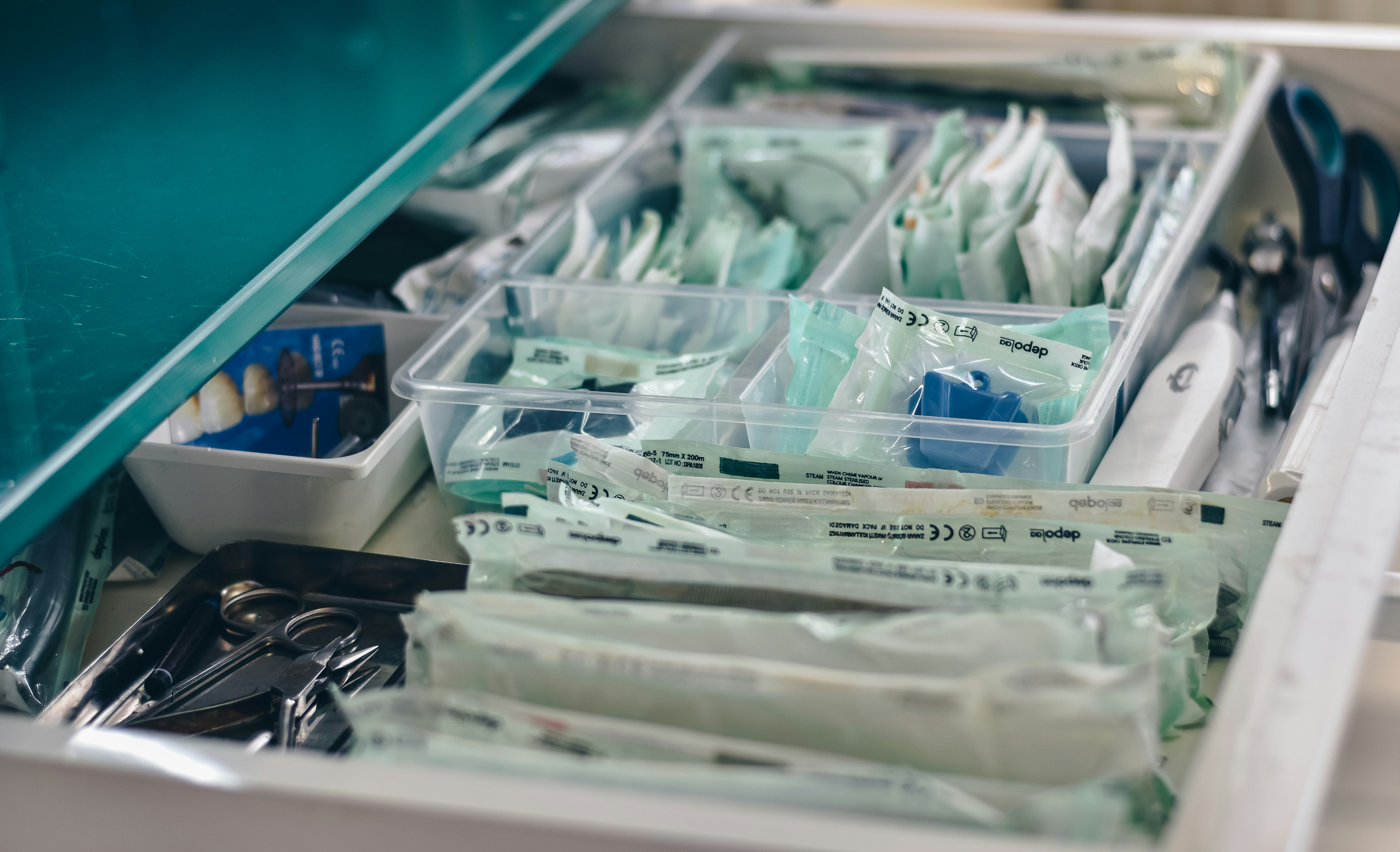 Organized and packaged dental supplies in a drawer.