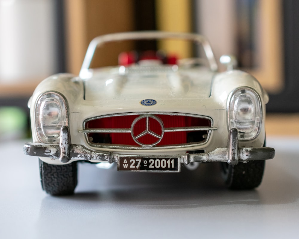 selective focus photography of white Mercedes-Benz convertible coupe scale model