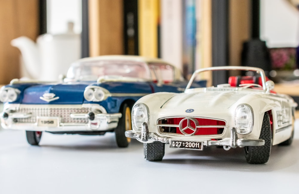 two white Mercedes-Benz near blue Cadillac car scale models