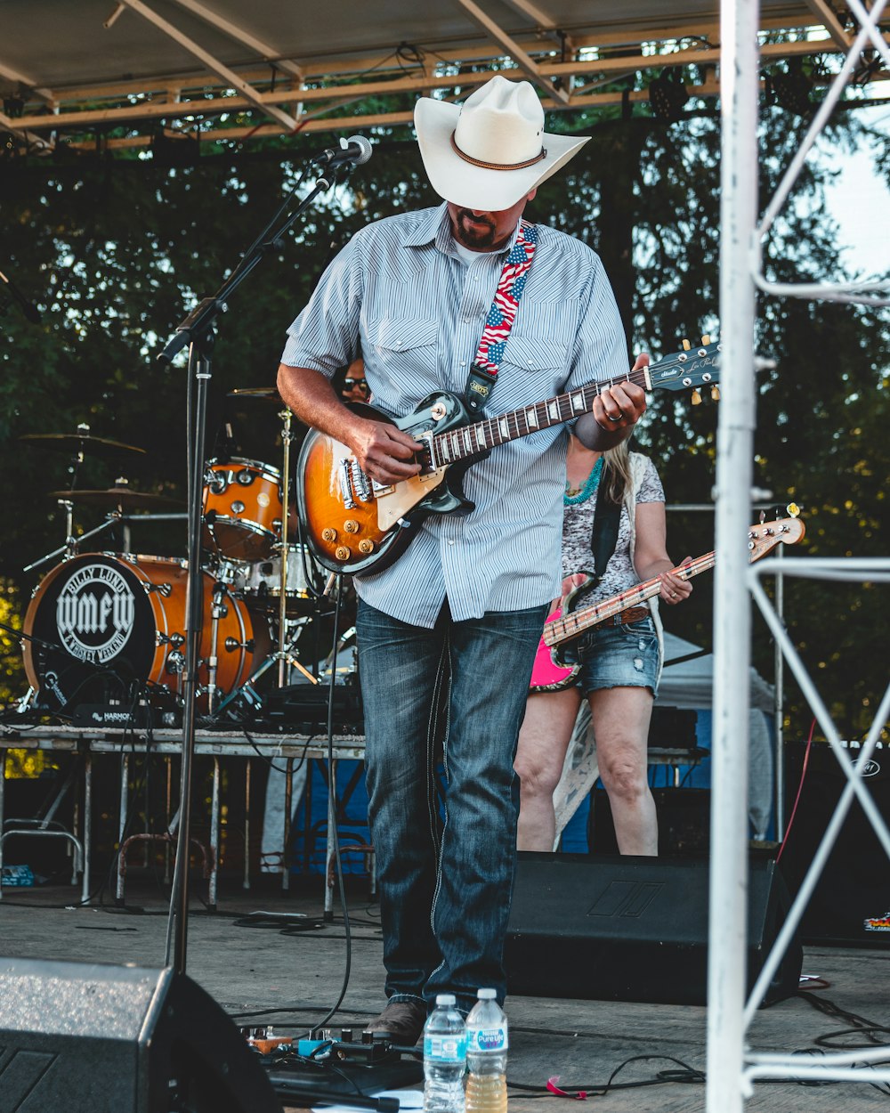 standing man on stage playing guitar