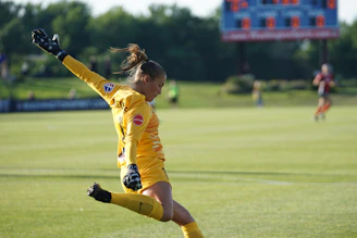 Close-up action shot of a soccer player scoring a goal.