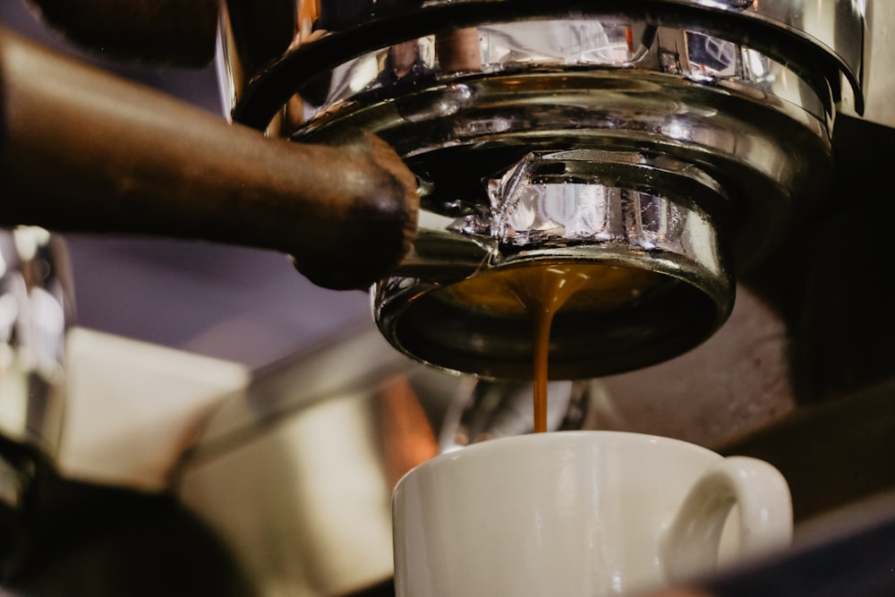 white ceramic mug under espresso maker