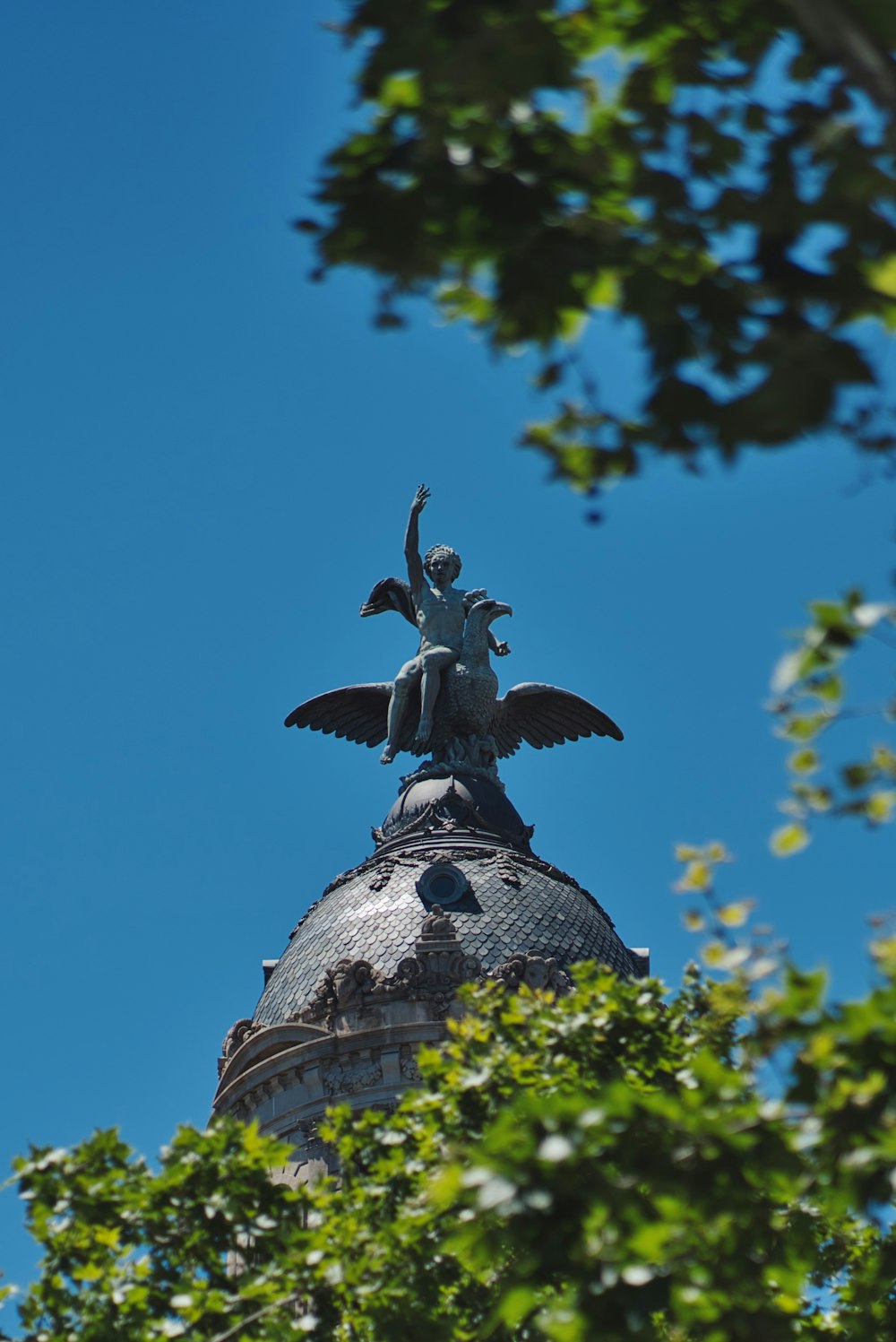 man sitting on a bird statue