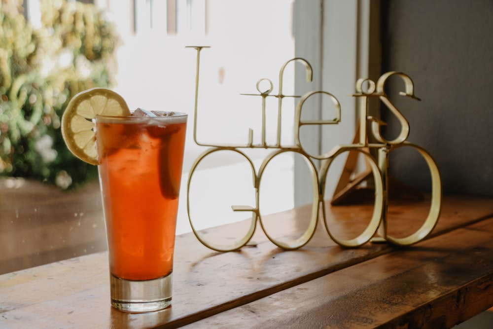 glass of drink beside life is good decorative letters