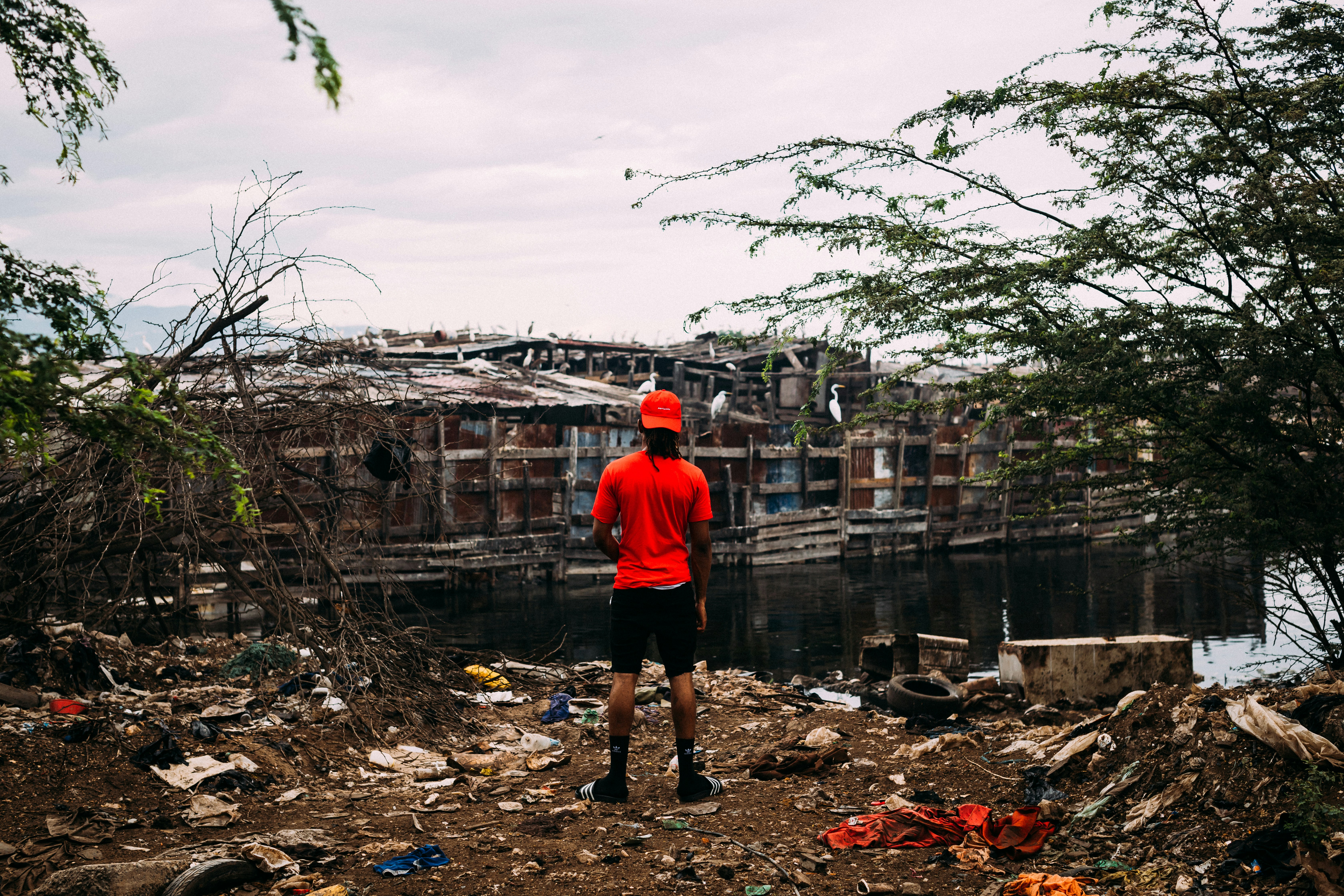 man in red shirt facing house