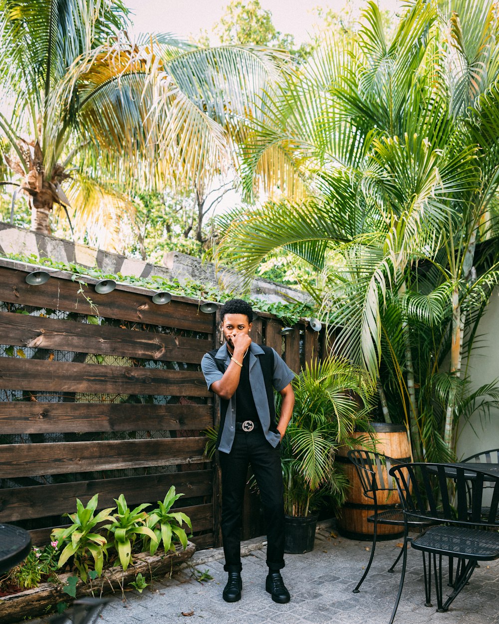 man standing near wooden wall at patio