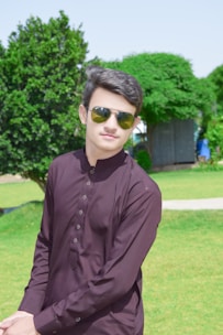 Indian man confidently sporting trendy grey sunglasses outdoors in bright sunlight.