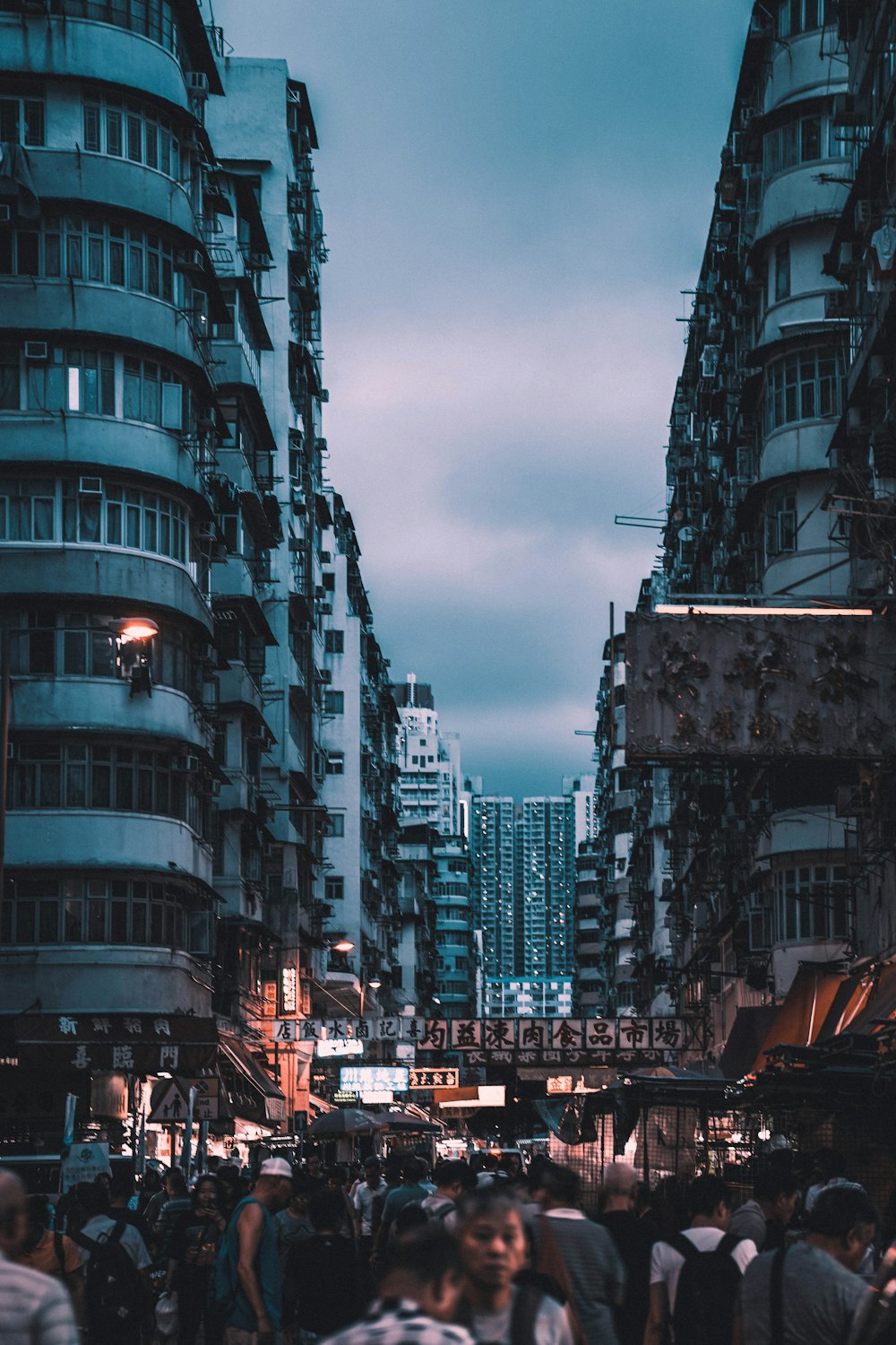 personas caminando entre edificios durante la noche
