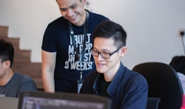 man standing behind sitting man
